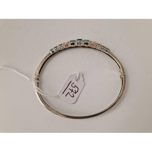 572 - A silver bangle with assorted stones