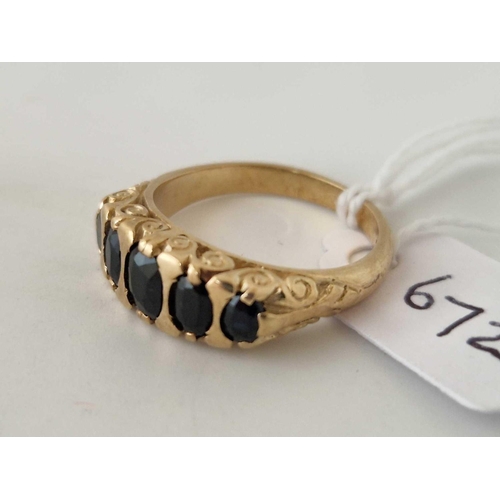 672 - A five stone carved half hoop ring set with sapphires 9ct size O