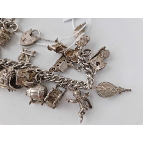 71 - A heavy silver charm bracelet 85g