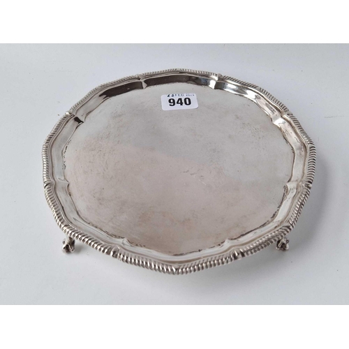 940 - A good shaped circular salver on four claw and ball feet, 8