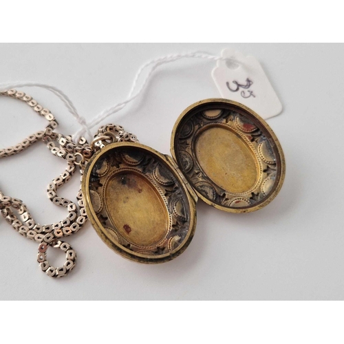 35 - A oval fancy locket in two colour gold on gilt square link box chain 15 inch