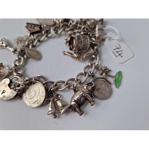 74 - A silver charm bracelet with 16 silver charms 47.4g