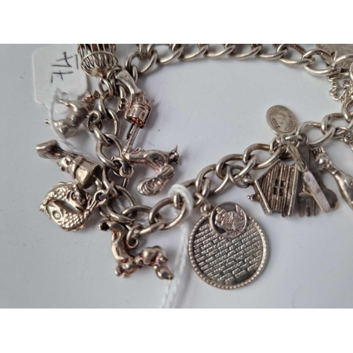 74 - A silver charm bracelet with 16 silver charms 47.4g