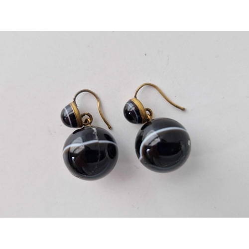 490 - A pair of banded agate ball earrings - One stone cracked and glued