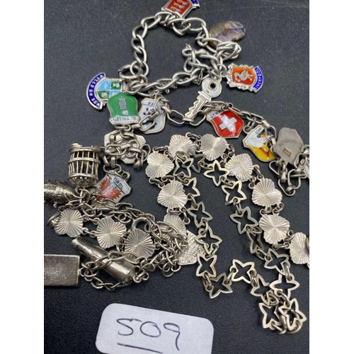 509 - A silver bracelets including charms and enamel fobs 36 gms