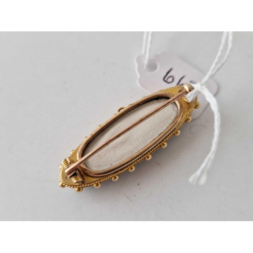 667 - A antique gold oval brooch onyx set with a leaf half pearl set in the centre