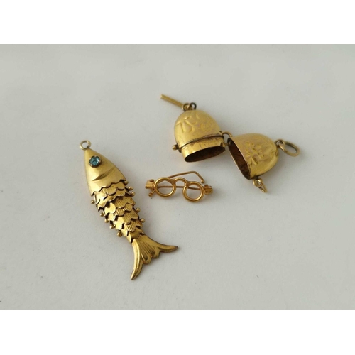 673 - Two antique gold charms 14ct gold an articulated fish with blue eyes and a spectacles case containin... 