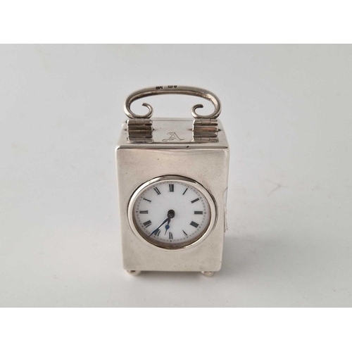 909 - A small silver cased travelling clock with circular aperture and swing handle, 3.5 inches high, Lond... 