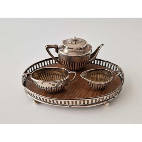 983 - A miniature three piece teaset on an oval tray, 3.5