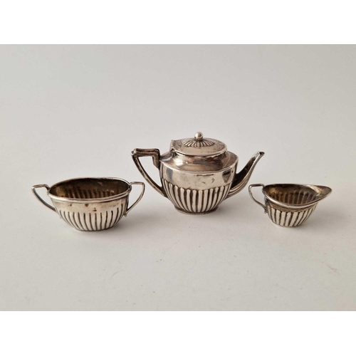 983 - A miniature three piece teaset on an oval tray, 3.5