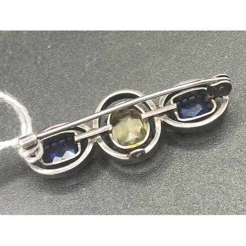 573 - A silver blue and yellow three stone paste set brooch