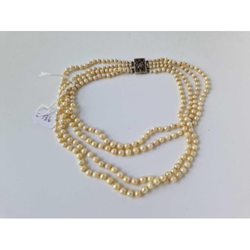 136 - A four strand pearl necklace with gold and silver diamond set clasp, 14 inch