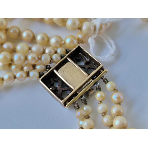 136 - A four strand pearl necklace with gold and silver diamond set clasp, 14 inch