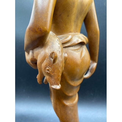 1822 - An Asian carved wood figure of a lady with a piglet, 17 inches high