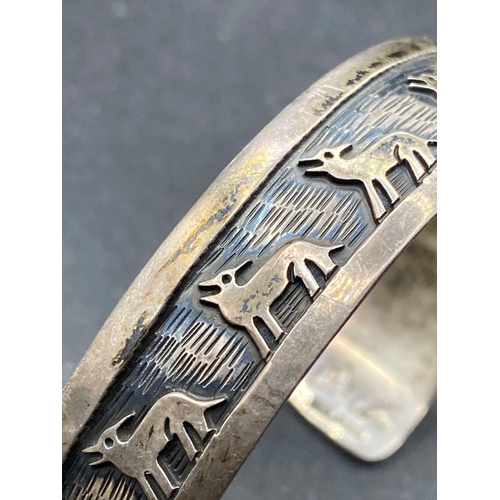 309 - A silver torque bangle with wolves design