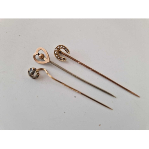 424 - A 15ct pearl horseshoe stick pin and two 9ct examples (heart and white stone)