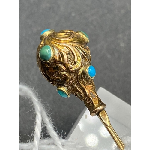 442 - A Victorian scrolled and embossed stick pin set with turquoise in high carat gold