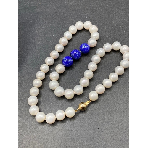 447 - A large fine round south sea pearl necklace 10 to 11 mm with central lapis detail with gold clasp 18... 