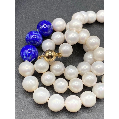 447 - A large fine round south sea pearl necklace 10 to 11 mm with central lapis detail with gold clasp 18... 