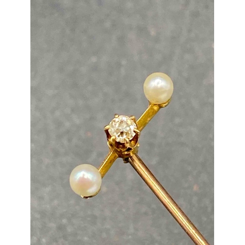 552 - A Victorian diamond and pearl three stone stick pin with screw top in high carat