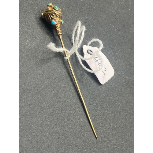 442 - A Victorian scrolled and embossed stick pin set with turquoise in high carat gold