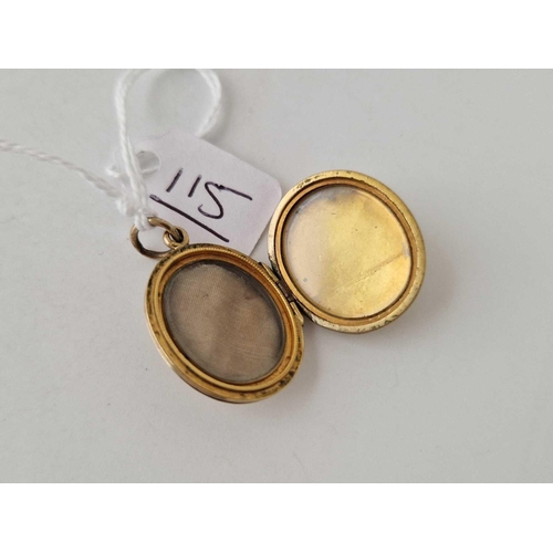 115 - A 15ct gold oval back and front locket with chased decoration