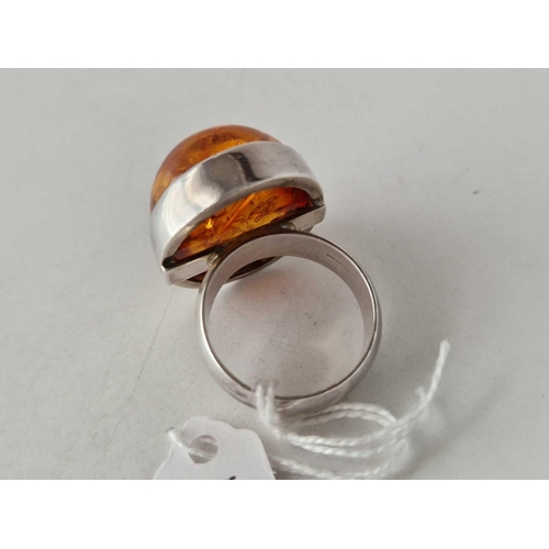 174 - A large silver cabochon amber ring, size Y