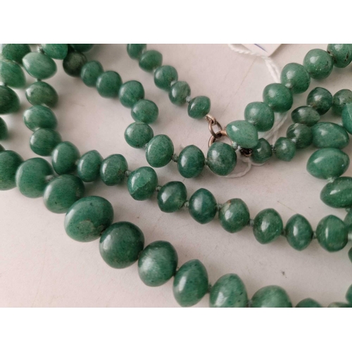 275 - A LONG STRING OF GRADUATED JADE BEADS