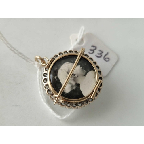 336 - A VICTORIAN CIRCULAR PENDANT BROOCH WITH HINGED LOCKET BACK SET WITH A CENTRAL CABOCHON ROCK CRYSTAL... 