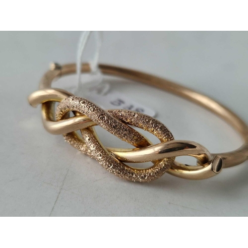 338 - A VICTORIAN GOLD BANGLE DESIGNED AS A LOVER KNOT 9CT