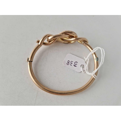 338 - A VICTORIAN GOLD BANGLE DESIGNED AS A LOVER KNOT 9CT