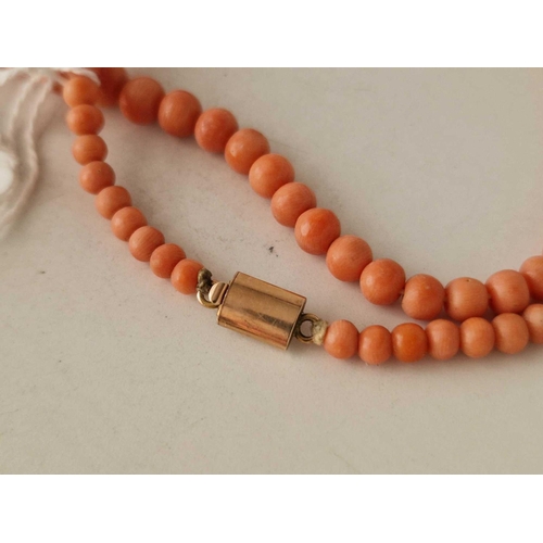 378 - A string of coral beads with gold clasp 18 inch 15.6 gms