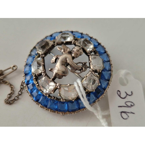 396 - An antique silver and paste circular cherub brooch