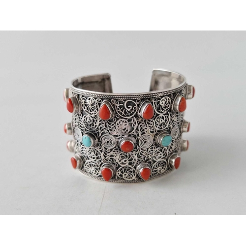 440 - A tribal silver wide cuff bangle set with corals and turquoise