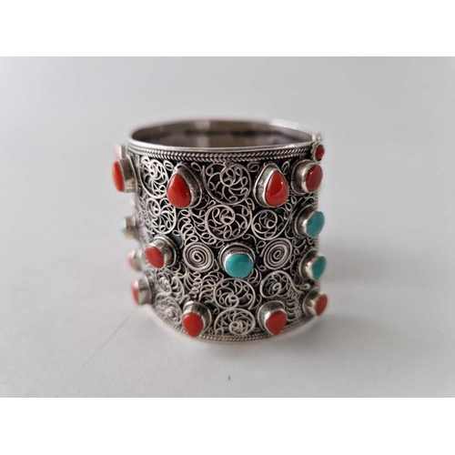 440 - A tribal silver wide cuff bangle set with corals and turquoise