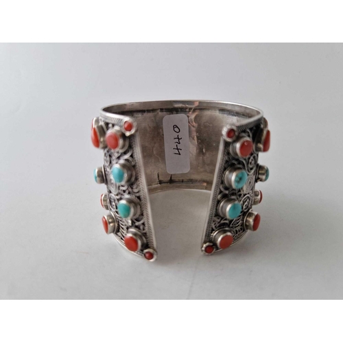 440 - A tribal silver wide cuff bangle set with corals and turquoise