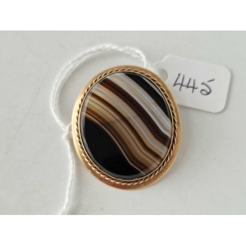 445 - An oval polished agate mounted brooch, 9ct