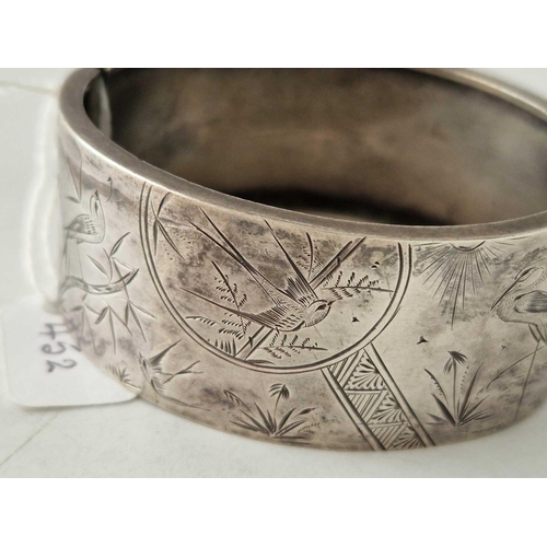 452 - A engraved silver bangle with bird decoration 30 gms