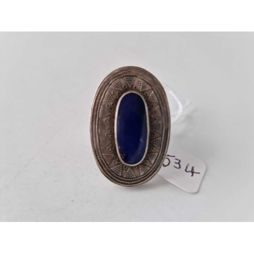 534 - A large oval tribal ring with geometric pattern and a central lapis size S