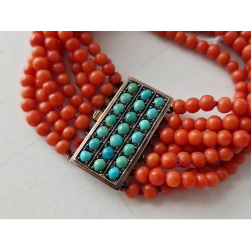 542 - A SEVEN STRAND CORAL BRACELET WITH GOLD AND TURQUOISE CLASP, 6 inch