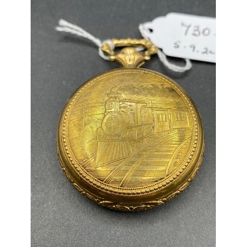 730 - A gents gilt pocket watch with railway engine design to reverse