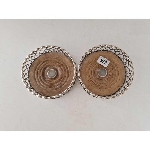 972 - A pair of Georgian wine coasters with wire work sides and wood bases with silver bosses, 5.5 inches ... 