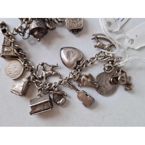 264 - A silver vintage charm bracelet with numerous charms 51g