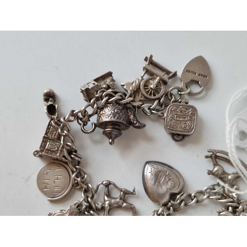 264 - A silver vintage charm bracelet with numerous charms 51g