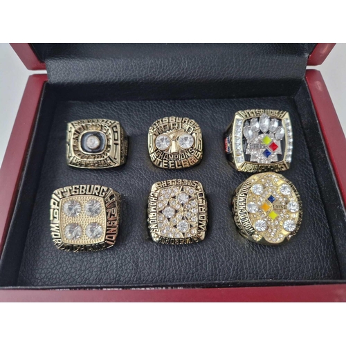 290 - A cased set of six championship American football elaborate stone set ring