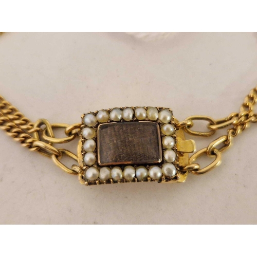 220 - A antique gold bracelet with a centre glazed rectangular mourning panel surrounded by half pearls