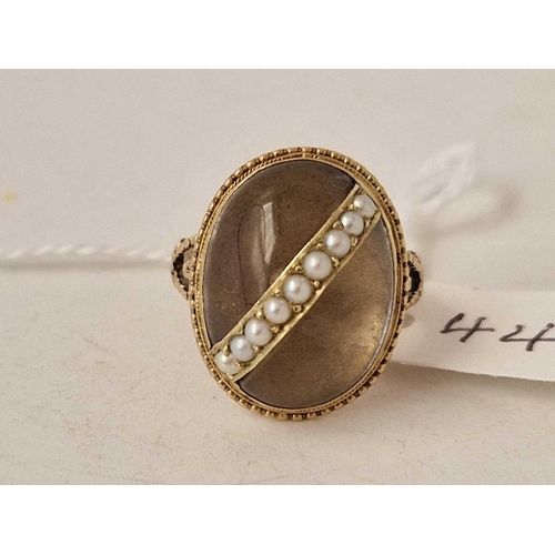 44 - Antique gold ring set with a large oval cabochon rock crystal with a row of pearls set across the mi... 