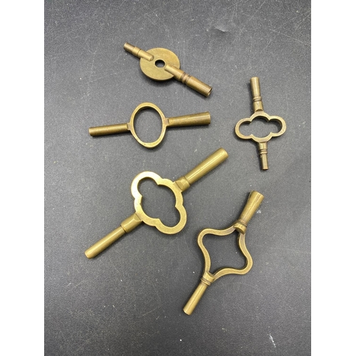 709 - five assorted brass travelling clock keys