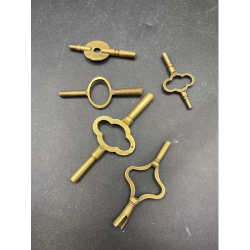 709 - five assorted brass travelling clock keys