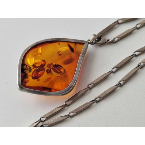 96 - A silver and amber pendant on chain and earrings 51 gms